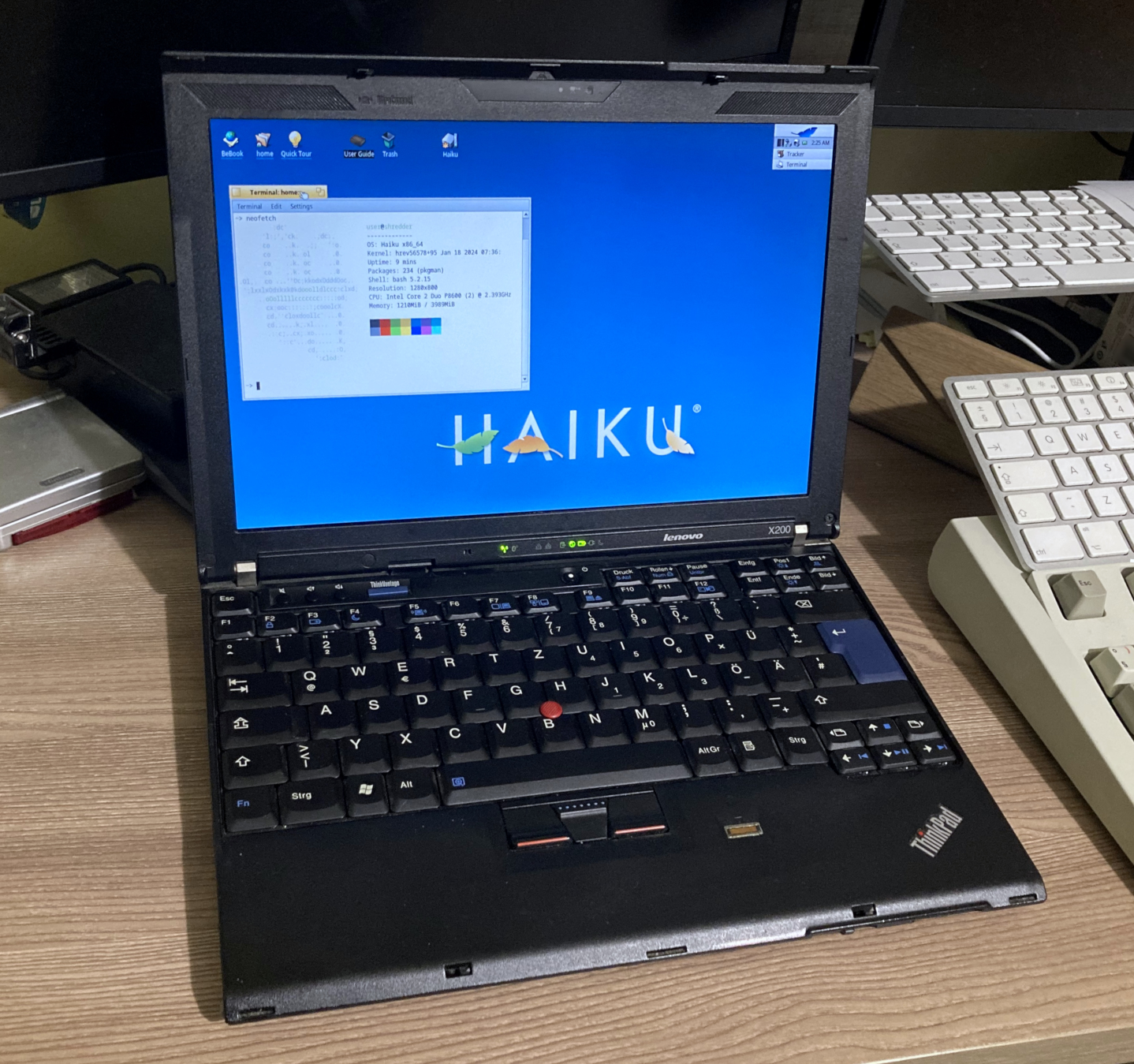 Picture of the laptop running Haiku OS, with neofetch in a terminal window